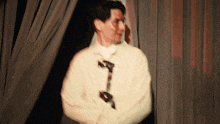 a man in a strait jacket stands in front of a curtain