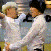 two men in white shirts are hugging each other