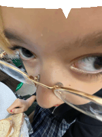 a girl wearing glasses is holding a sandwich