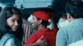 a man in a red hat holds a woman in a white shirt