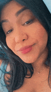 a woman wearing a necklace with a heart shaped pendant