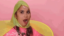 a woman in a pink jacket and a yellow raincoat is wearing a plastic raincoat .