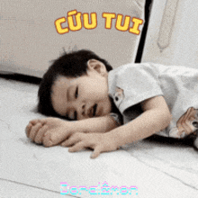 a little boy is laying on the floor with cuu tui written on the bottom