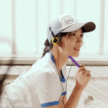 a woman wearing headphones and a baseball cap that says kuunk basketball