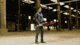 a man in a black leather jacket and purple tie is holding a sword