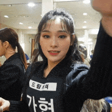 a woman wearing a black shirt that says ' a ' on it