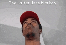 a man wearing a red hat is looking up with the words `` the writer likes him bro '' above him .