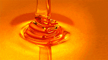 a close up of honey being poured into a cup