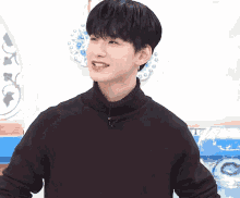 a young man wearing a black sweater is making a funny face .