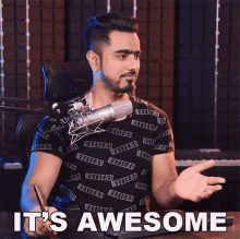 a man sitting in front of a microphone with the words it 's awesome on the bottom