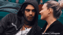 a man wearing a givova sweatshirt looks at a woman