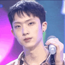 a close up of a young man holding a microphone on a stage .