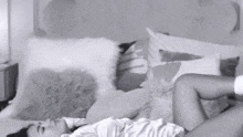a woman is laying on her stomach on a bed with pillows .