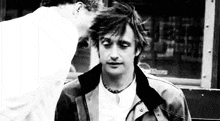 a black and white photo of two men kissing each other .