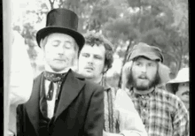 a black and white photo of a group of men standing next to each other .