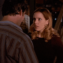 a man and a woman are standing next to each other and the woman is making a face