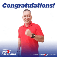 a man in a red shirt stands in front of a congratulations sign