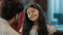 a little girl is smiling at her father while looking at him .