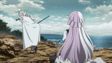 a man and a woman are standing next to each other on a rocky cliff .