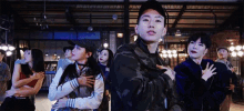 a group of people are standing in a room with their hands on their hearts .