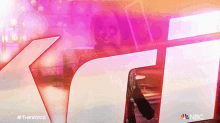 a nbc ad for the voice shows a woman in a purple background