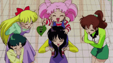 a group of girls are standing around a girl with a heart on her head