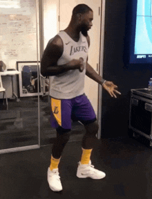 a man wearing a lakers jersey is dancing