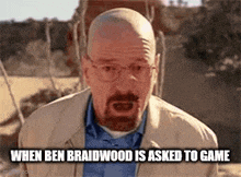 a bald man with glasses and a beard is standing in a field and making a funny face .