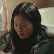 a woman is sitting in a bathtub with a towel hanging on the wall behind her