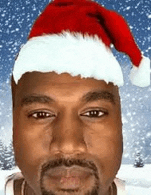 a man with a beard is wearing a santa hat in the snow .