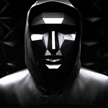 a black and white photo of a person wearing a hooded mask with a white t on it