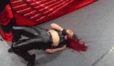 a woman with red hair is laying on the floor with her legs crossed .