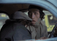 a man wearing a hat is talking to another man