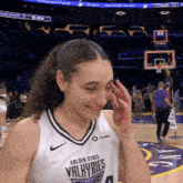 a female basketball player for the golden state valkyries wipes her face