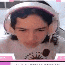 a close up of a person wearing headphones and a white shirt .