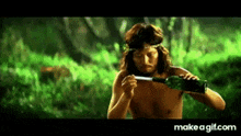 a shirtless man is holding a bottle of green liquid in a jungle .