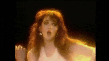 a woman with red hair is singing into a microphone in a dark room .