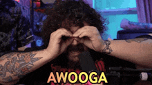 a man with curly hair and a beard is covering his eyes with his hands and the word awooga is on the bottom .