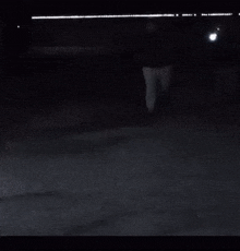 a man is dancing in the dark on a street .