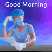 a surgeon wearing a mask and goggles is sitting at a table with a laptop and a good morning message