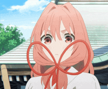 a girl with pink hair is wearing a red bow around her neck