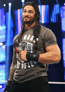 a wrestler with long hair and a shirt that says hard is softer
