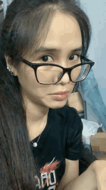 a woman wearing glasses and a t-shirt that says ' ao ' on it