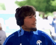 a man wearing headphones and a soccer ball on his jacket