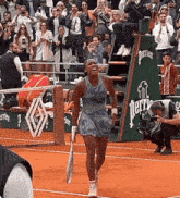 a woman holding a tennis racquet on a tennis court