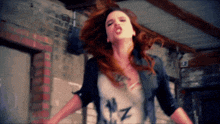 a woman with red hair is wearing a shirt that says nz on it