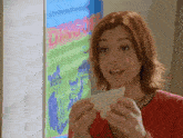 a woman is holding a piece of bread in front of a dingo poster
