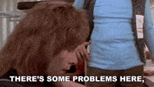 a woman says " there 's some problems here " in front of a man in a blue shirt