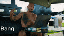 a shirtless man sits at a table with a laptop and bang written on the screen