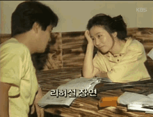 a man and a woman are sitting at a table talking in korean